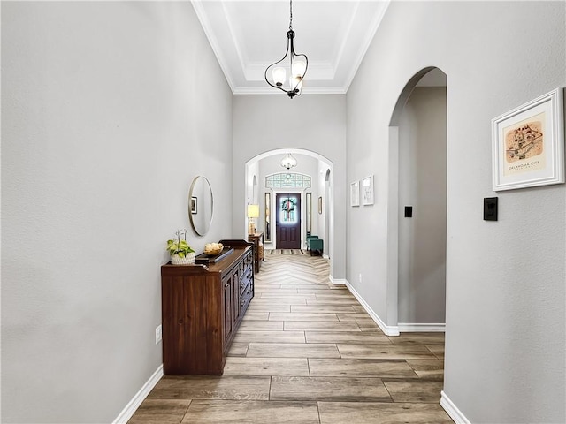 corridor with crown molding and a notable chandelier