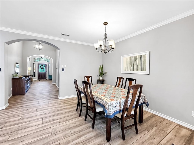 dining area featuring ornamental molding and a notable chandelier