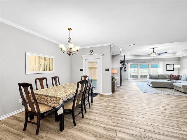 dining space featuring crown molding and ceiling fan with notable chandelier