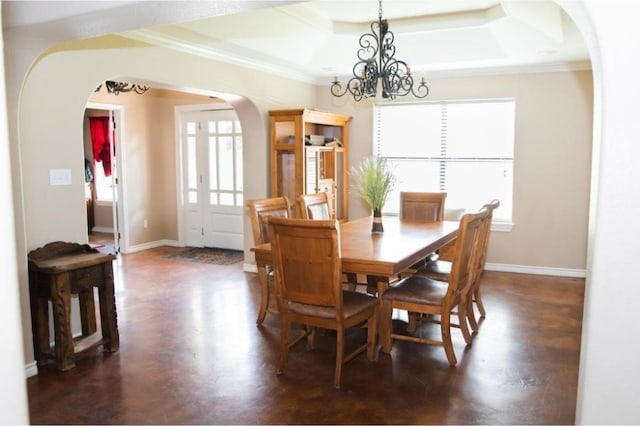 dining space featuring dark wood-type flooring, a tray ceiling, a notable chandelier, and crown molding