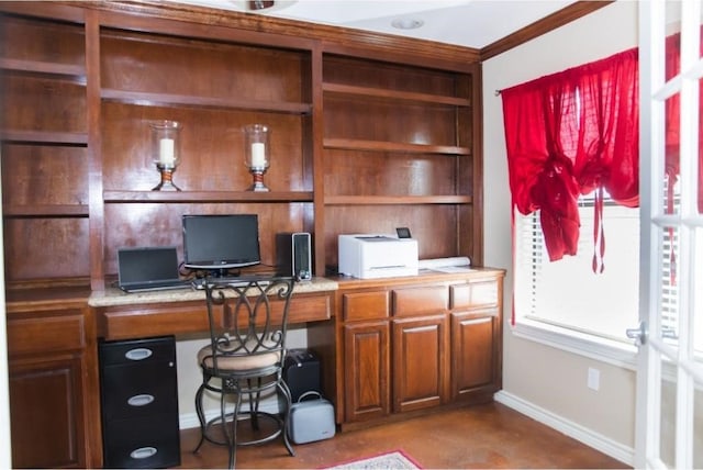 office space with built in desk and crown molding