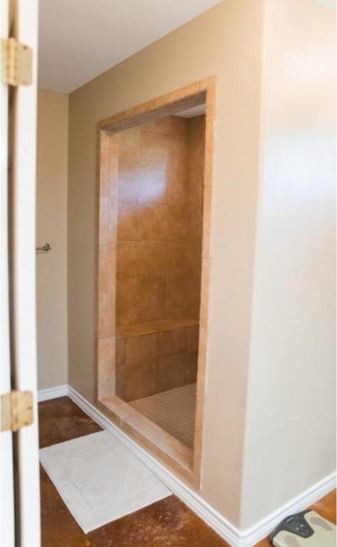 bathroom featuring tile patterned flooring and a tile shower