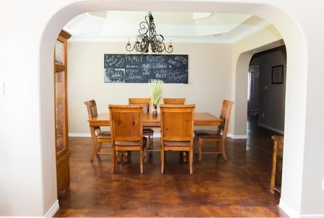 dining space featuring ornamental molding, a raised ceiling, and a notable chandelier