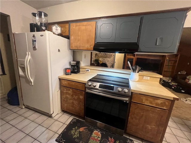11506 Turkey Creek Dr, Corpus Christi, TX 78410 - kitchen featuring stainless steel electric range, under cabinet range hood, light tile patterned floors, white refrigerator with ice dispenser, and light countertops