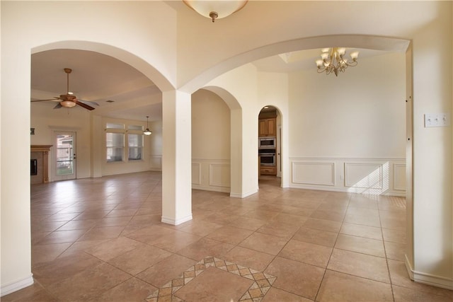 6825 Old Square Dr, Corpus Christi, TX 78414 - empty room featuring a decorative wall, a ceiling fan, light tile patterned flooring, and a wainscoted wall