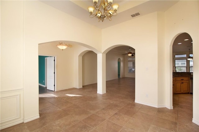 6825 Old Square Dr, Corpus Christi, TX 78414 - empty room with arched walkways, a towering ceiling, a chandelier, and ceiling fan