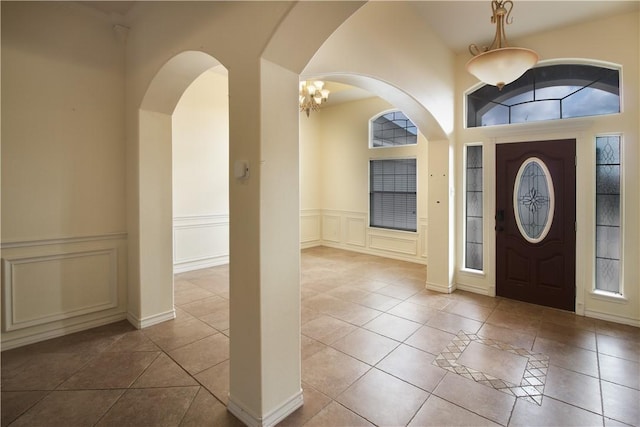 6825 Old Square Dr, Corpus Christi, TX 78414 - tiled foyer entrance with a decorative wall, arched walkways, and a wainscoted wall