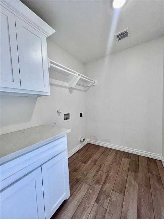 laundry room with cabinets, washer hookup, dark wood-type flooring, and hookup for an electric dryer