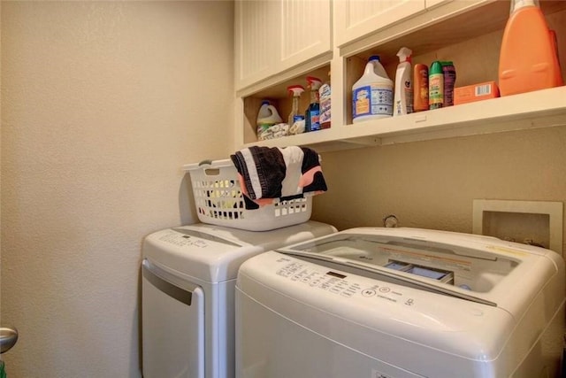 washroom featuring cabinets and washer and dryer