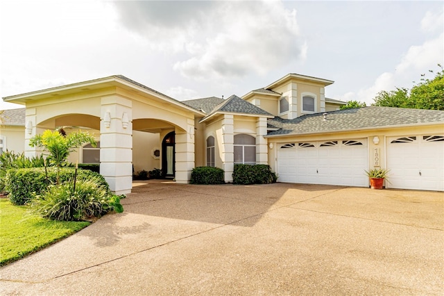 7906 Valtourmanche Dr, Corpus Christi, TX 78414 - mediterranean / spanish house featuring concrete driveway, a garage, stucco siding, and a shingled roof