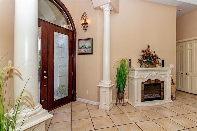 7906 Valtourmanche Dr, Corpus Christi, TX 78414 - foyer with decorative columns, light tile patterned flooring, baseboards, and a glass covered fireplace