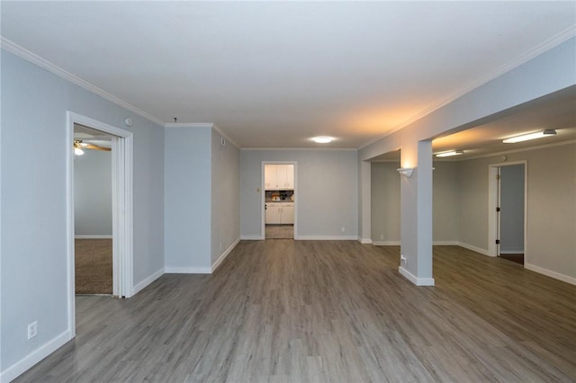 interior space featuring wood-type flooring, ceiling fan, and ornamental molding