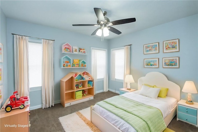 carpeted bedroom featuring multiple windows and ceiling fan