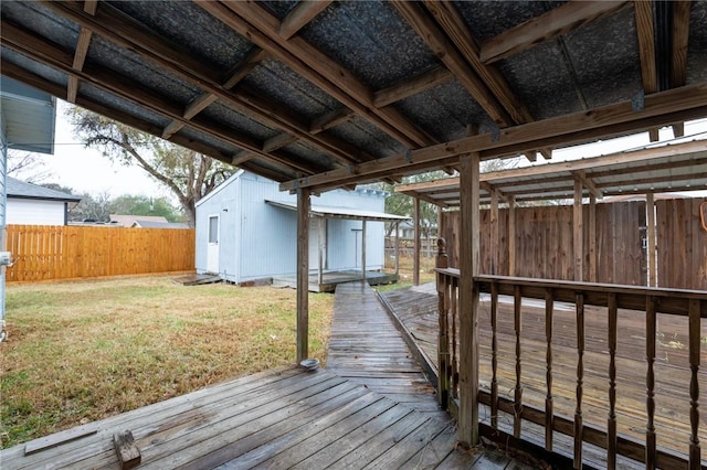 wooden deck featuring a lawn and an outbuilding