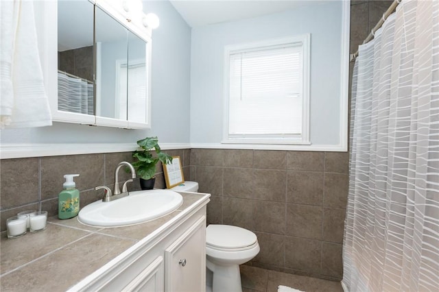 bathroom with vanity, tile walls, and toilet