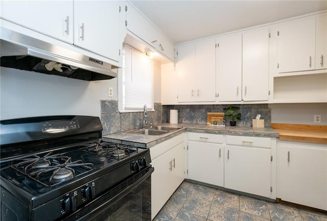 kitchen with backsplash, black range with gas stovetop, white cabinetry, and sink