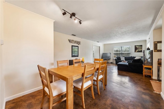 dining space with baseboards and finished concrete floors