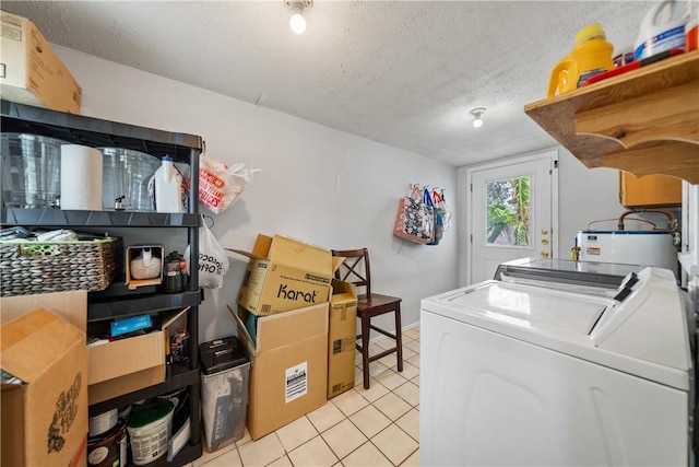 laundry room with light tile patterned floors, laundry area, a textured ceiling, and washer and clothes dryer