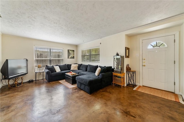 living area with concrete flooring, a textured ceiling, and baseboards