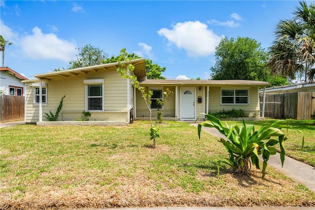 ranch-style home featuring fence and a front yard