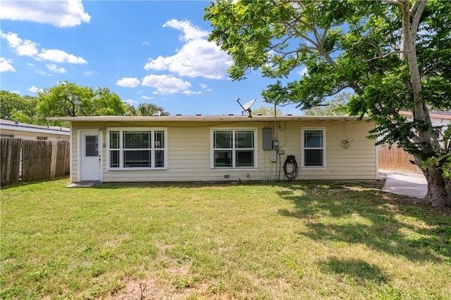 back of house with a lawn and fence