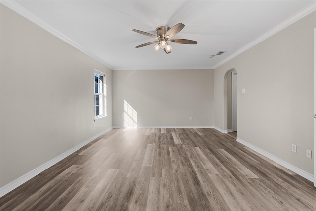 empty room featuring ceiling fan, hardwood / wood-style floors, and ornamental molding