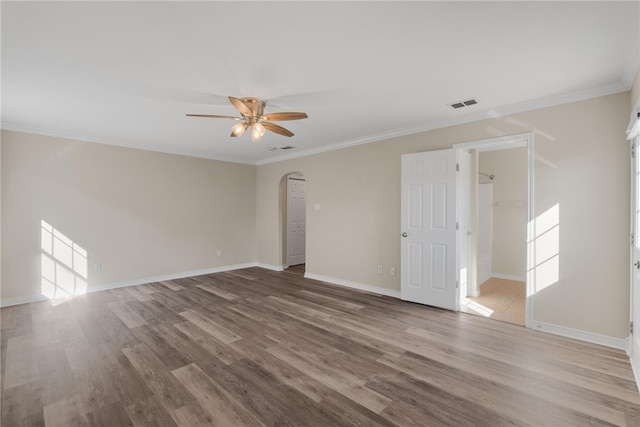 empty room with ornamental molding, wood-type flooring, and ceiling fan