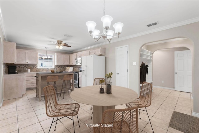 dining area featuring ceiling fan with notable chandelier, light tile patterned floors, and crown molding