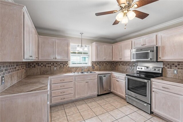 15522 Finistere St, Corpus Christi, TX 78418 - kitchen with stainless steel appliances, light brown cabinetry, light tile patterned floors, and crown molding