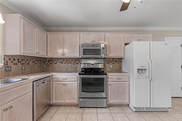 kitchen with light brown cabinets, light tile patterned flooring, appliances with stainless steel finishes, and tasteful backsplash