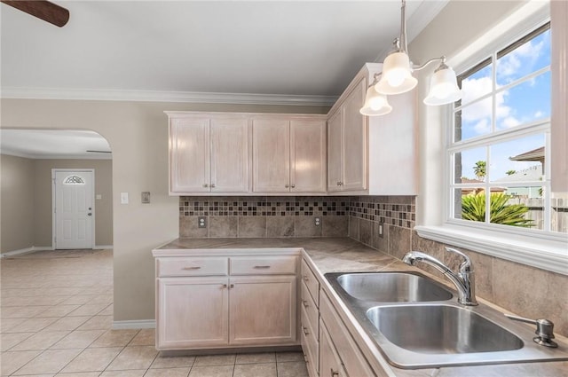 15522 Finistere St, Corpus Christi, TX 78418 - kitchen featuring arched walkways, light tile patterned floors, backsplash, crown molding, and hanging light fixtures