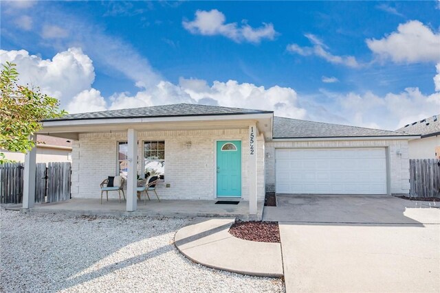 15522 Finistere St, Corpus Christi, TX 78418 - single story home with a porch, brick siding, an attached garage, and driveway