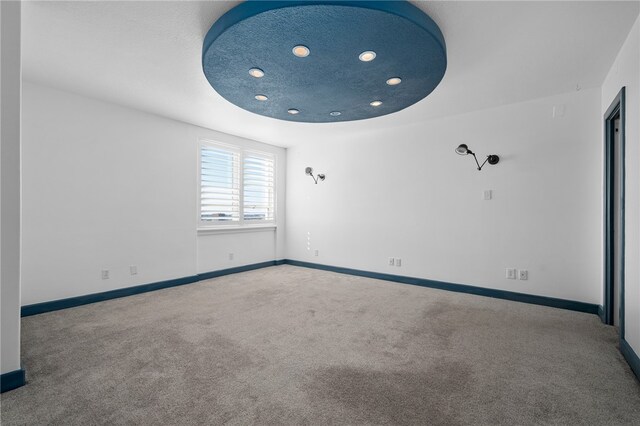 unfurnished room with a textured ceiling and carpet flooring