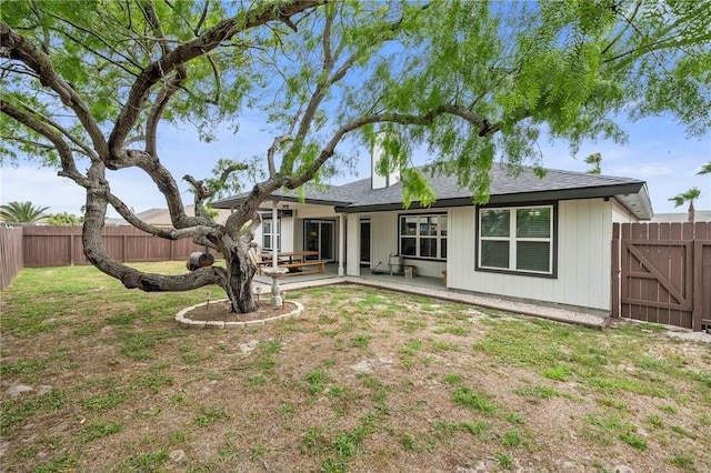 back of house with a patio, a fenced backyard, and a lawn