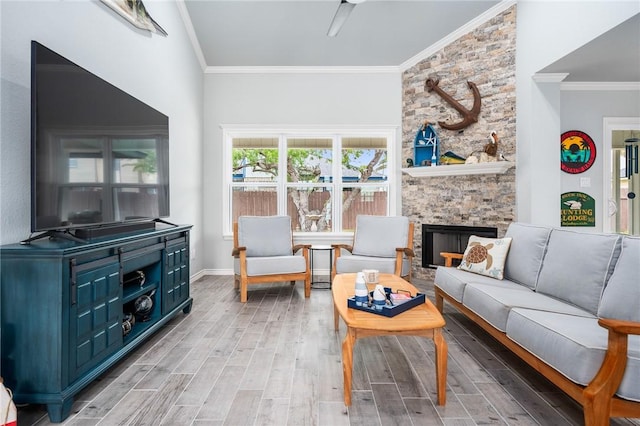 living room featuring baseboards, ornamental molding, wood finished floors, and a fireplace