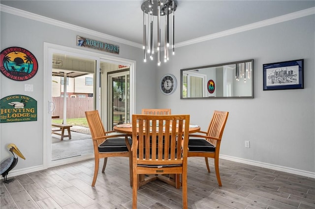dining room featuring crown molding, baseboards, and wood finished floors