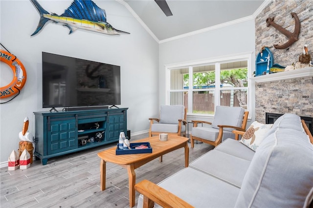 living area featuring a stone fireplace, ornamental molding, baseboards, and wood finished floors