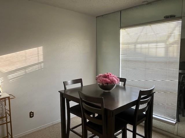 dining area with carpet flooring and a textured ceiling