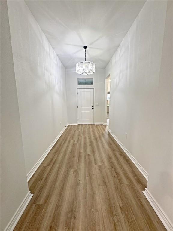 9505 Spanish Oak Dr, Corpus Christi, TX 78410 - entryway featuring wood finished floors, a chandelier, and baseboards