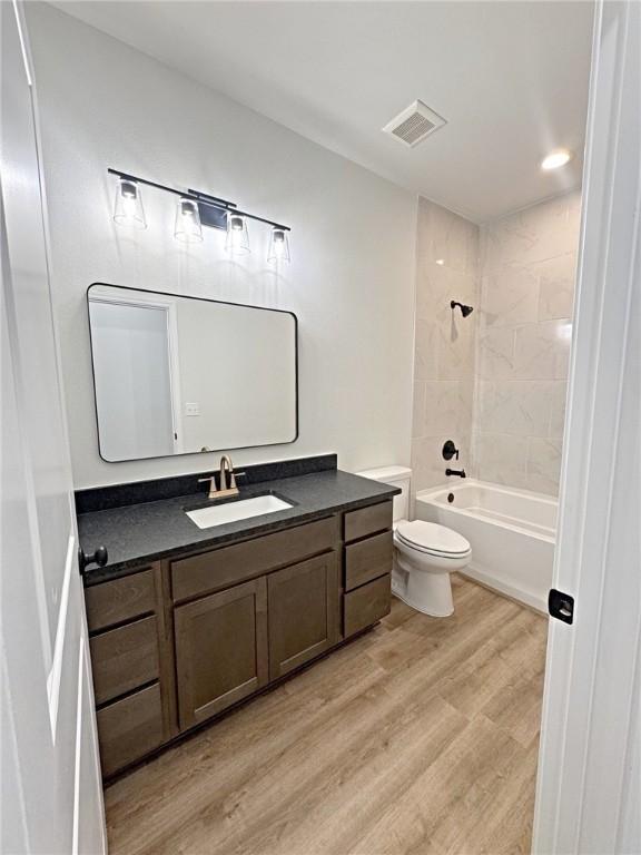 9505 Spanish Oak Dr, Corpus Christi, TX 78410 - bathroom with wood finished floors, toilet, vanity, and bathing tub / shower combination