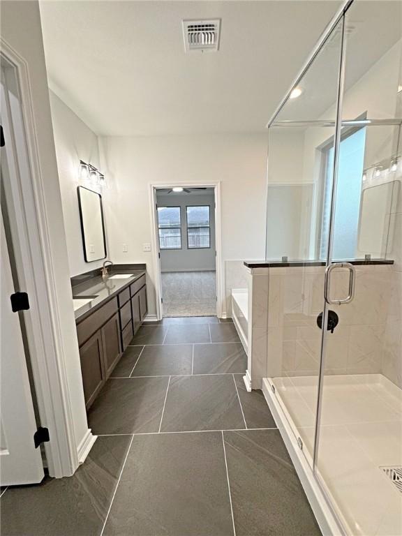 9505 Spanish Oak Dr, Corpus Christi, TX 78410 - full bath with a garden tub, a stall shower, double vanity, and baseboards