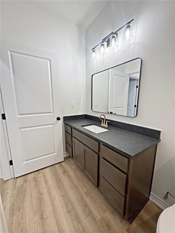9505 Spanish Oak Dr, Corpus Christi, TX 78410 - bathroom with wood finished floors, vanity, and toilet