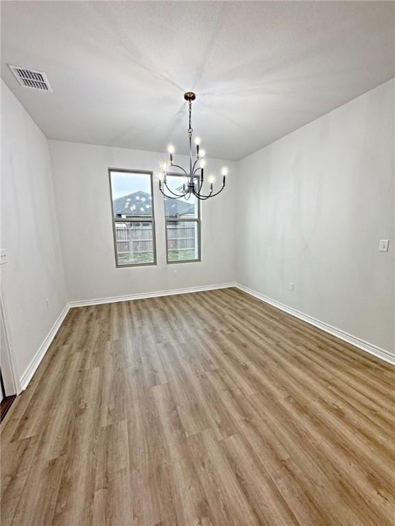 9505 Spanish Oak Dr, Corpus Christi, TX 78410 - spare room featuring a chandelier, wood finished floors, and baseboards