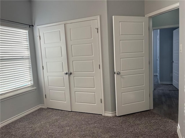 unfurnished bedroom featuring carpet floors, a closet, and baseboards