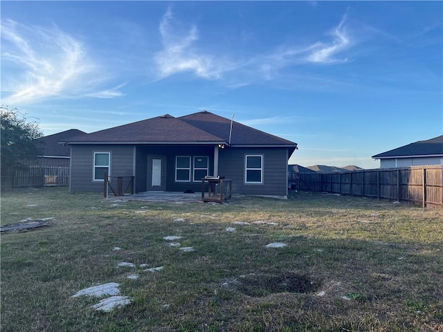 rear view of house featuring a patio area, a fenced backyard, and a lawn