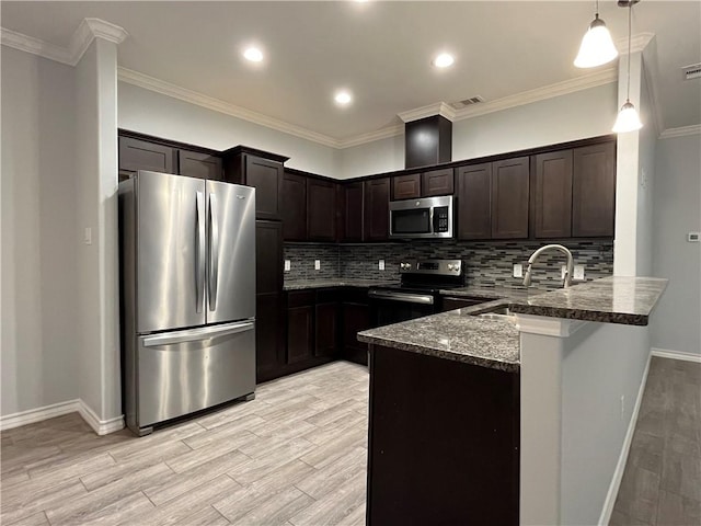 kitchen with stainless steel appliances, visible vents, a sink, dark stone counters, and a peninsula