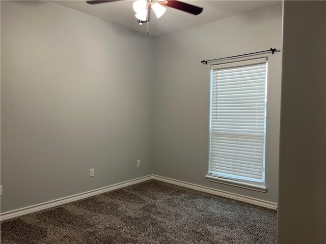 carpeted spare room with ceiling fan and baseboards