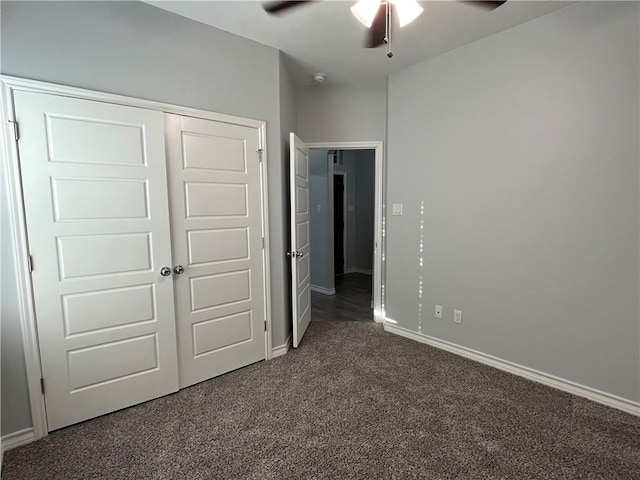 unfurnished bedroom featuring a ceiling fan, dark colored carpet, a closet, and baseboards