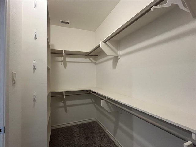 walk in closet with visible vents and dark carpet