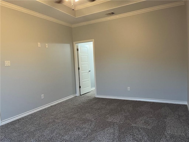 spare room with visible vents, baseboards, ornamental molding, dark colored carpet, and a raised ceiling